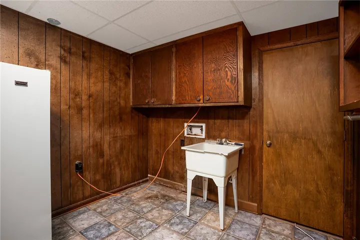 Functional laundry space with ample cabinet storage and utility sink.