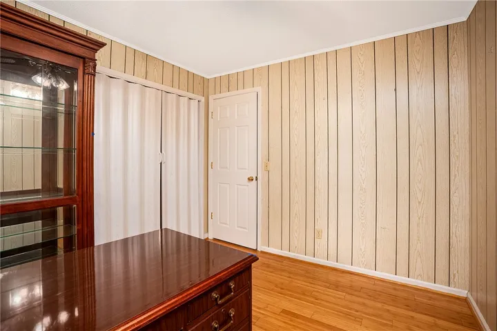 Blonde wood paneling and natural wood floors create a warm, inviting atmosphere in this versatile interior space.