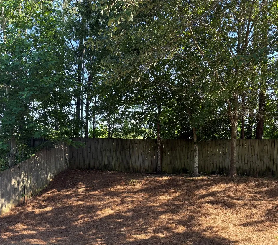 Secure backyard retreat with a wood privacy fence and mature trees for natural shading.