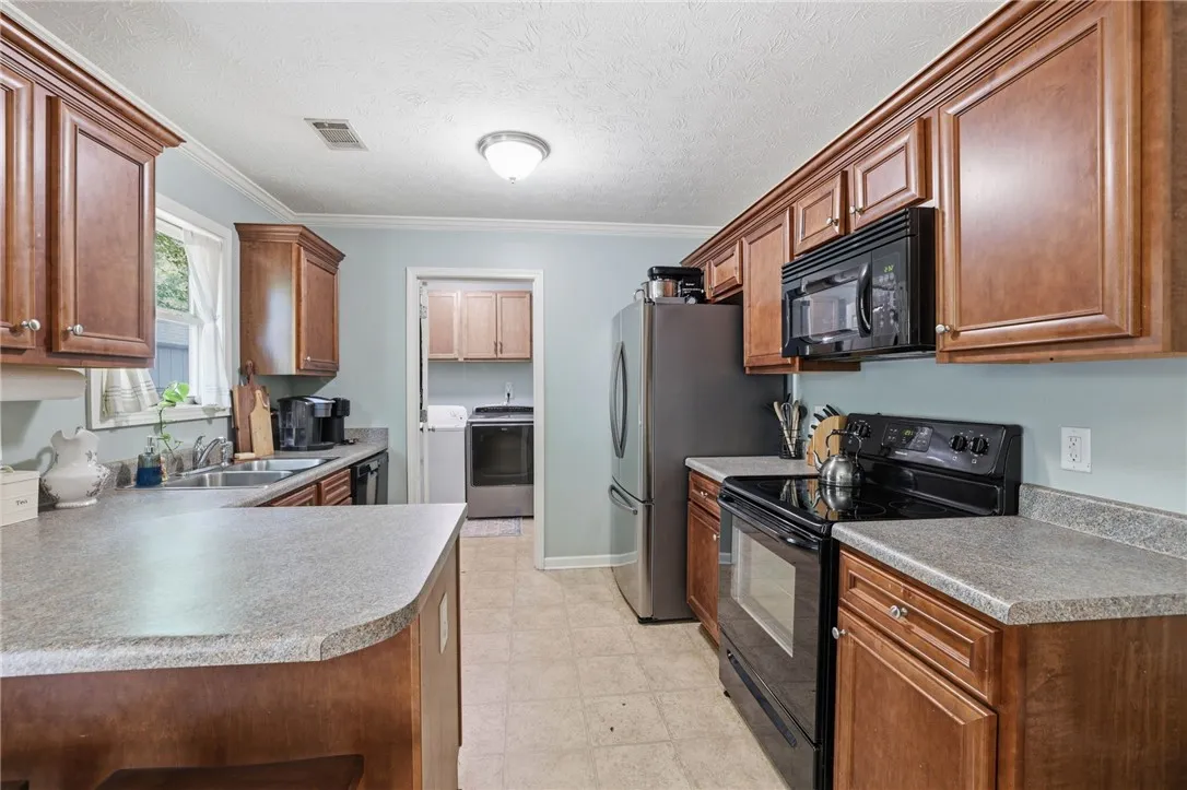 This kitchen showcases ample cabinetry and functional appliances, offering an inviting culinary space.