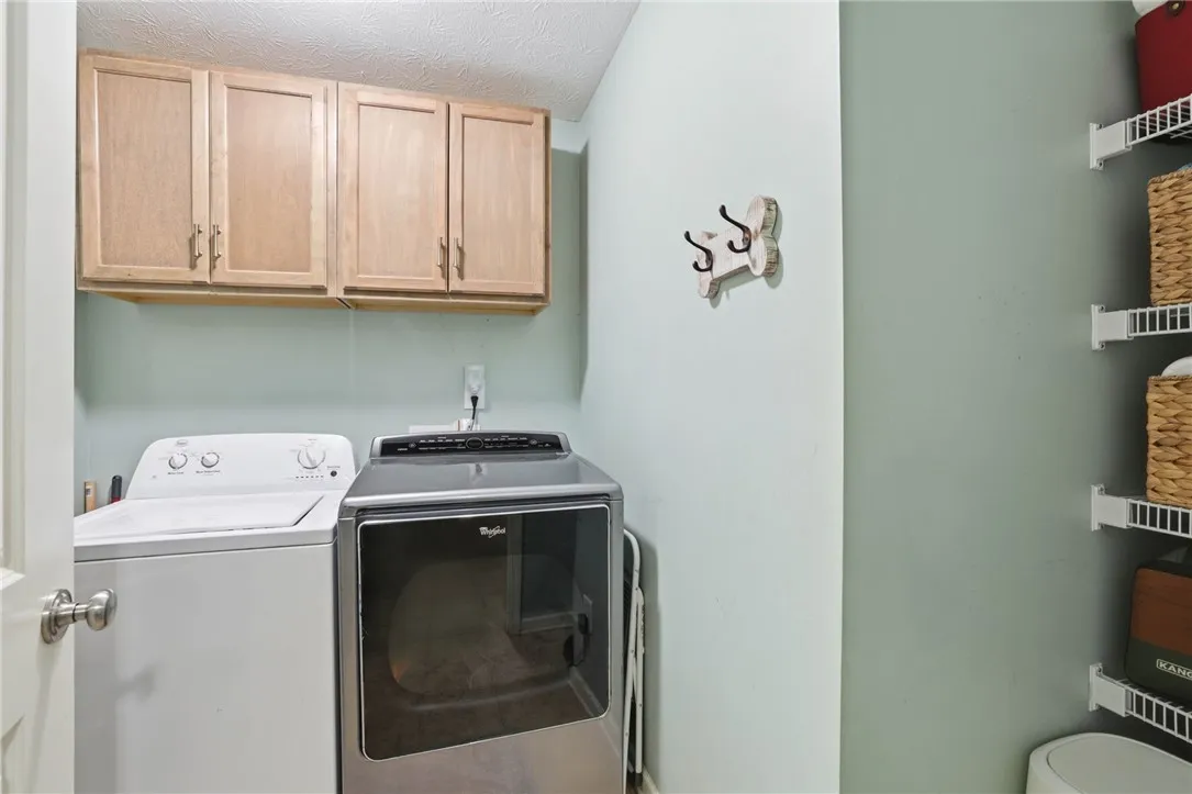 Functional laundry room featuring overhead cabinetry for organized storage.