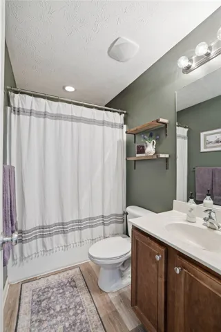 This bathroom features durable flooring, and an efficient vanity with storage.