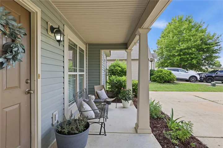Welcome to a charming front porch retreat, offering a serene space for outdoor relaxation.