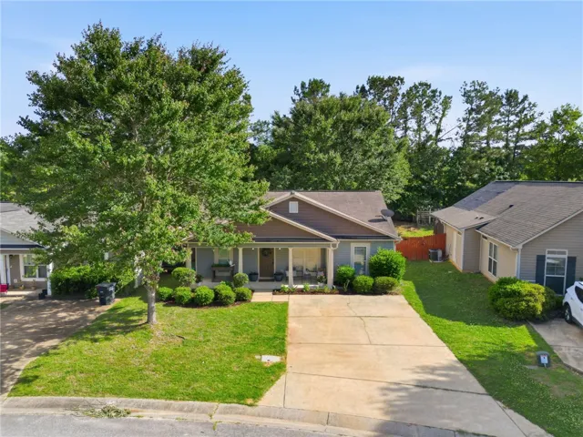A welcoming facade with a covered porch and established front yard landscaping.