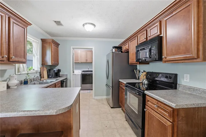 This kitchen showcases ample cabinetry and functional appliances, offering an inviting culinary space.
