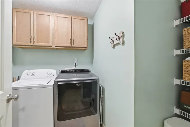 Functional laundry room featuring overhead cabinetry for organized storage.