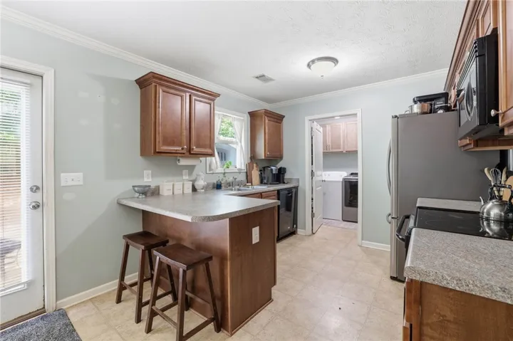 A well-appointed kitchen features a practical breakfast bar and direct access to a utility space.