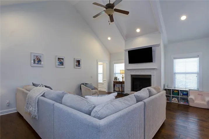 Bright and airy living room with a vaulted ceiling and a classic fireplace.