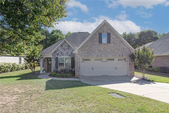 This charming home showcases a beautiful blend of brick and stone with an inviting front entrance.