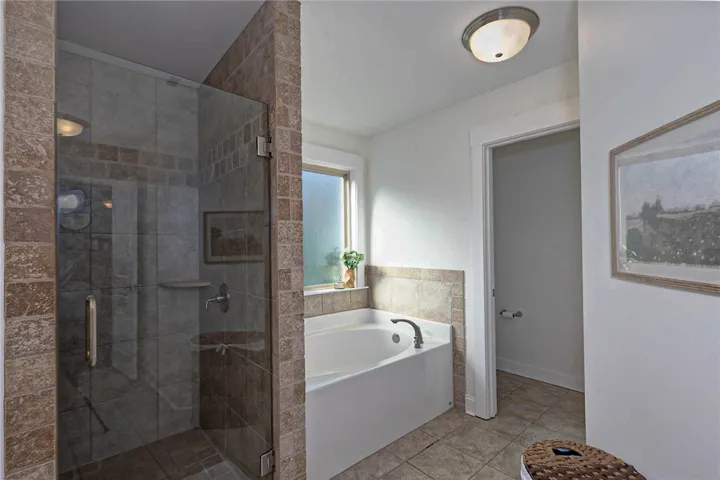 This bathroom features a shower and a soaking tub, offering both convenience and relaxation.
