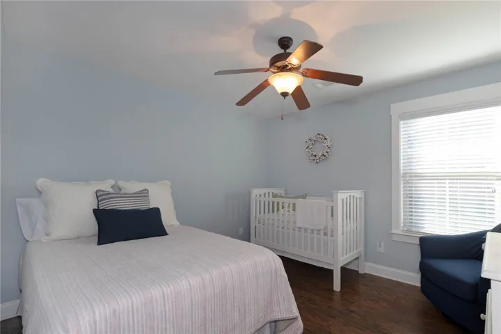 This serene bedroom offers ample light and comfortable flooring for relaxation.