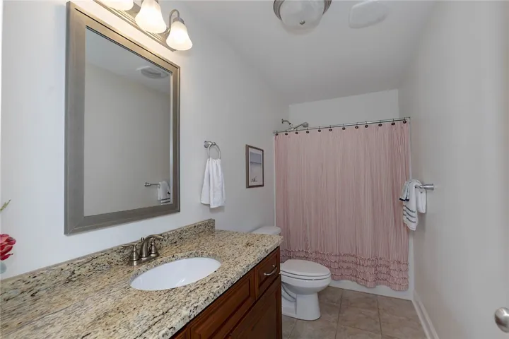 This bathroom features a sleek vanity with ample counter space and a classic shower.