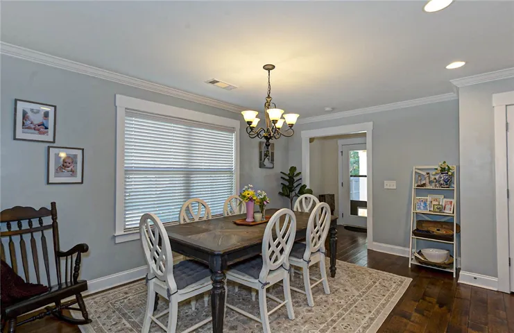 This inviting dining area features crown molding and rich hardwood flooring, creating an ideal setting for gatherings.