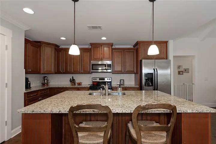 This spacious kitchen offers a central island, ample cabinetry, and modern appliances for culinary pursuits.