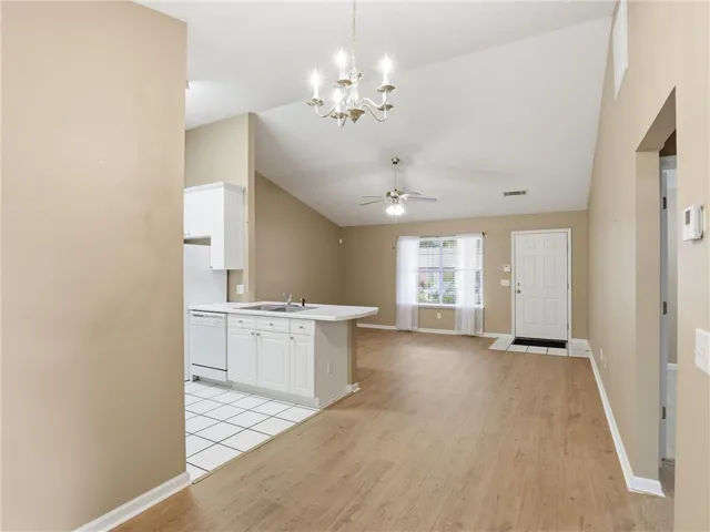 An inviting open-concept living space features high ceilings and seamless flow between the kitchen and living areas.