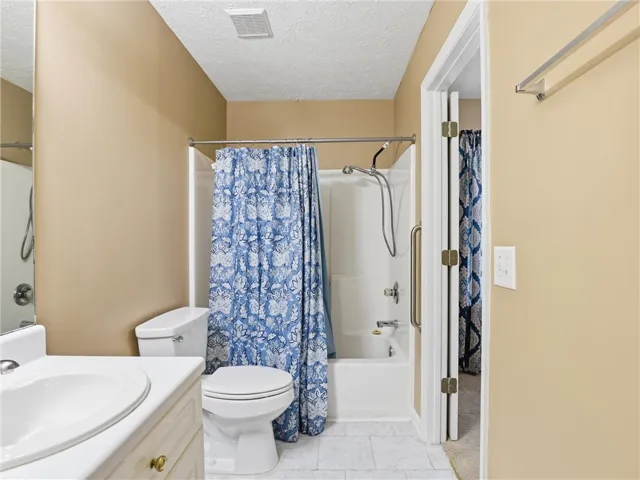 This bathroom features a functional vanity with ample storage, a full shower-tub combination, and tiled flooring.