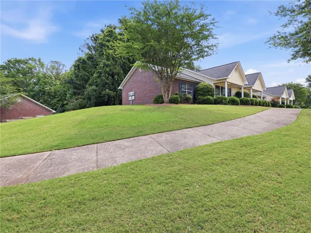 This charming home features a well-maintained exterior with a classic brick facade and lush landscaping. Situated on a spacious corner lot.