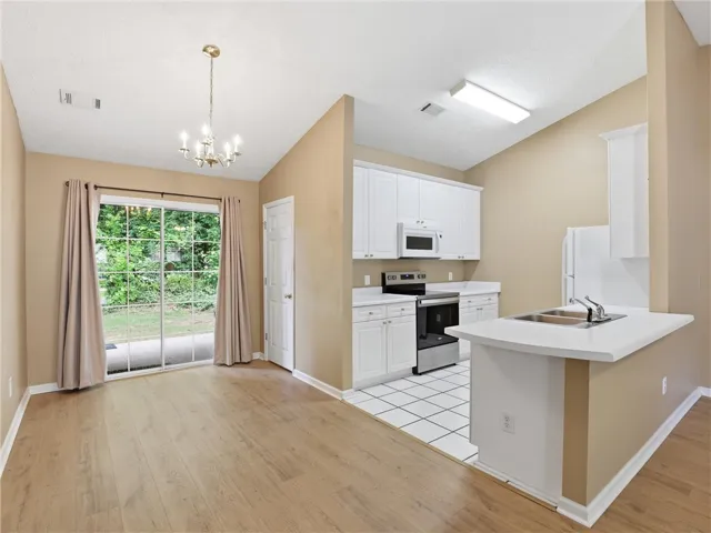 This inviting space combines a functional kitchen with a bright dining area, perfect for everyday living.