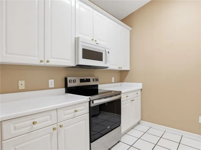 This kitchen features crisp white cabinetry and essential appliances for daily living.