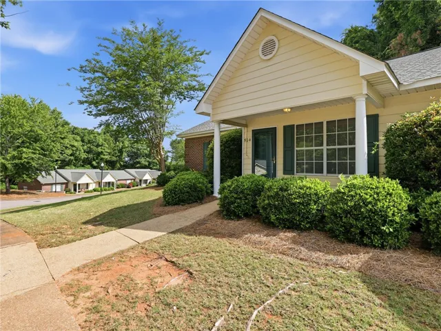 This charming home offers a welcoming facade with classic details and lush landscaping.