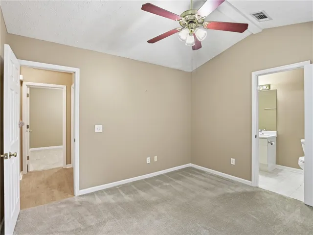 This cozy bedroom features plush carpeting and a convenient en-suite bathroom for added comfort.
