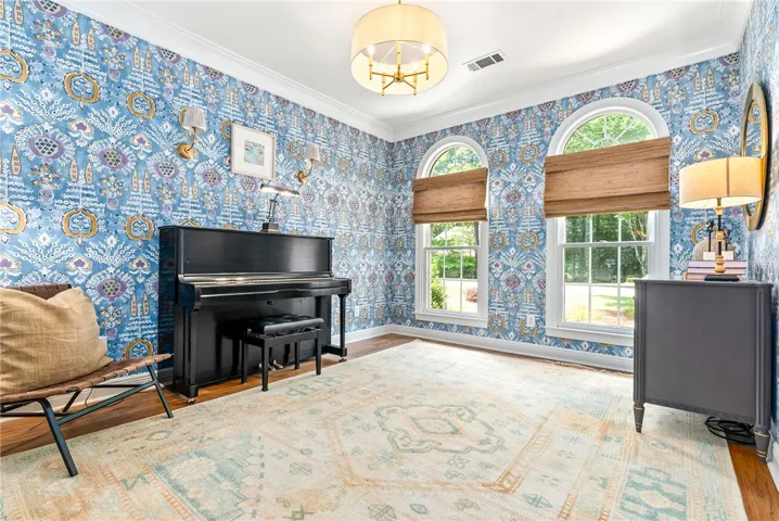 This vibrant room features arched windows, hardwood floors, and unique wall coverings, creating an inviting atmosphere.