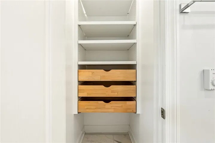 This organized closet features ample shelving and convenient drawers for optimal storage solutions.
