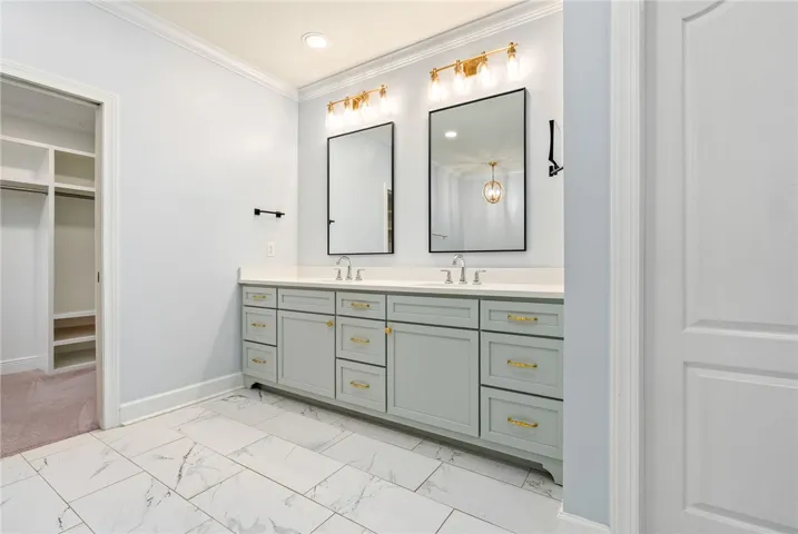 This spacious primary bathroom features a double vanity and an adjoining walk-in closet.
