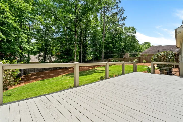 This spacious deck overlooks a verdant yard, offering a private outdoor retreat.