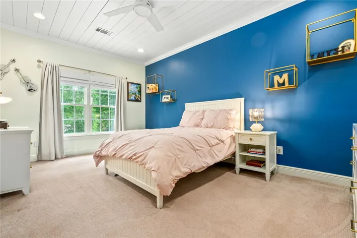 This inviting bedroom features a cozy bed and ample natural light from large windows.