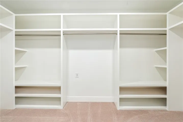 This spacious closet features ample shelving and hanging rods for organized storage.