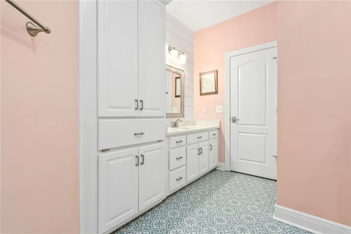 This bathroom features a double vanity and spacious storage, offering both style and practicality.