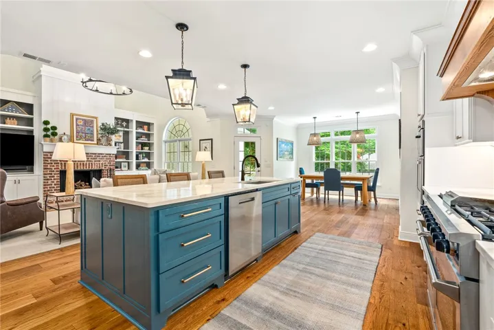 This open concept kitchen and dining area features rich wood flooring and abundant natural light.