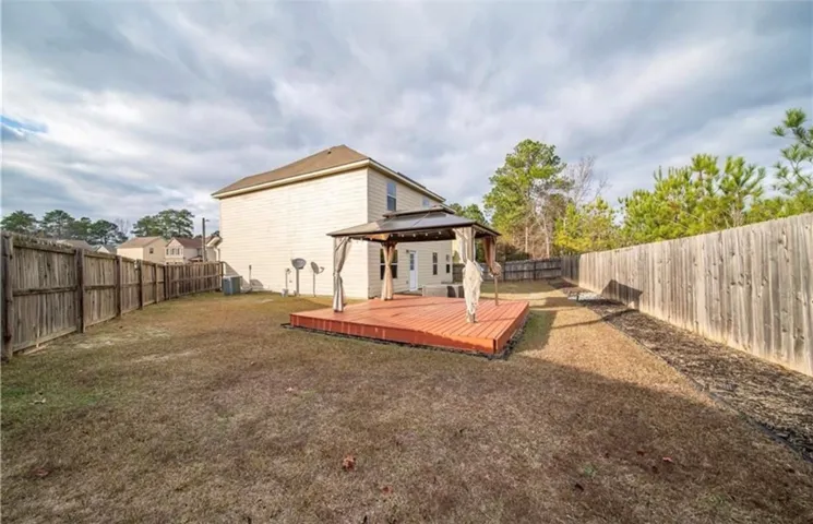 This spacious backyard features a gazebo-covered deck, perfect for outdoor enjoyment and entertaining.