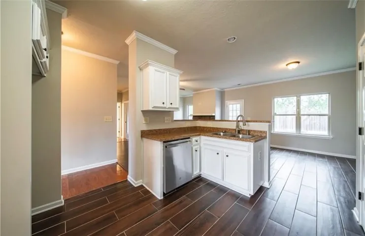 This bright kitchen features wood flooring and a dishwasher, perfect for modern living.
