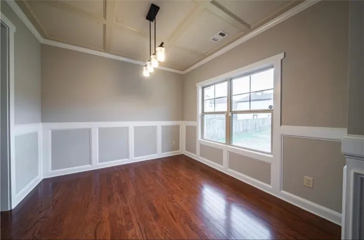 This bright space features rich hardwood flooring and distinctive wainscoting, perfect for diverse uses.