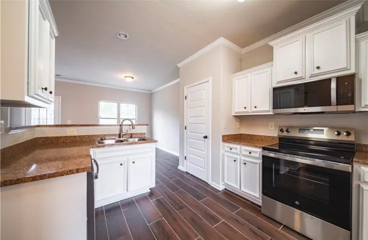 This spacious kitchen features ample counter space and modern appliances, perfect for everyday living.
