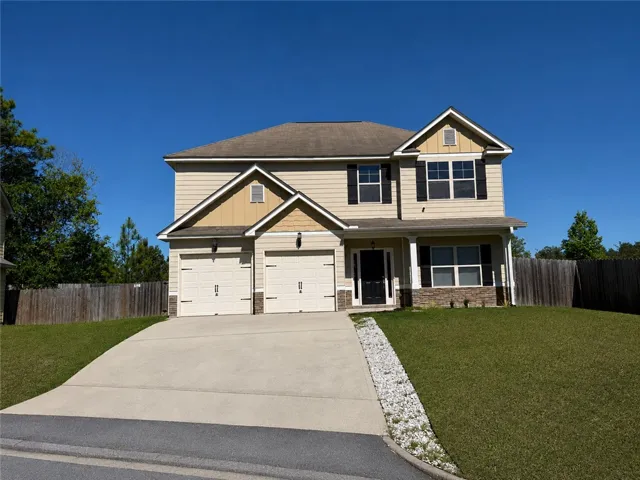This classic two-story home features a charming facade and a spacious driveway leading to the dual garages.