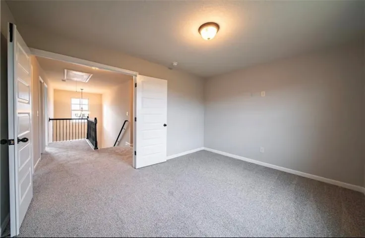 This spacious interior room offers versatile living possibilities with soft carpeting and natural light.