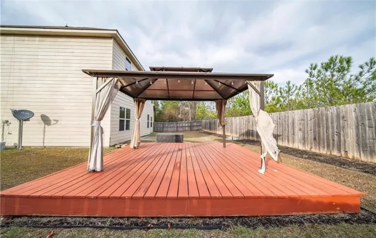 This spacious outdoor deck with a pergola offers an ideal setting for relaxation and entertainment.