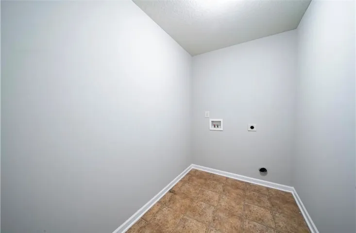 This dedicated utility space features durable flooring and essential hookups, offering a practical area for chores.