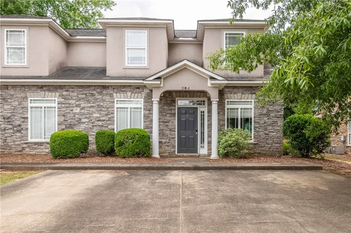 A refined facade features stone construction and a welcoming covered entrance, offering exceptional curb appeal.