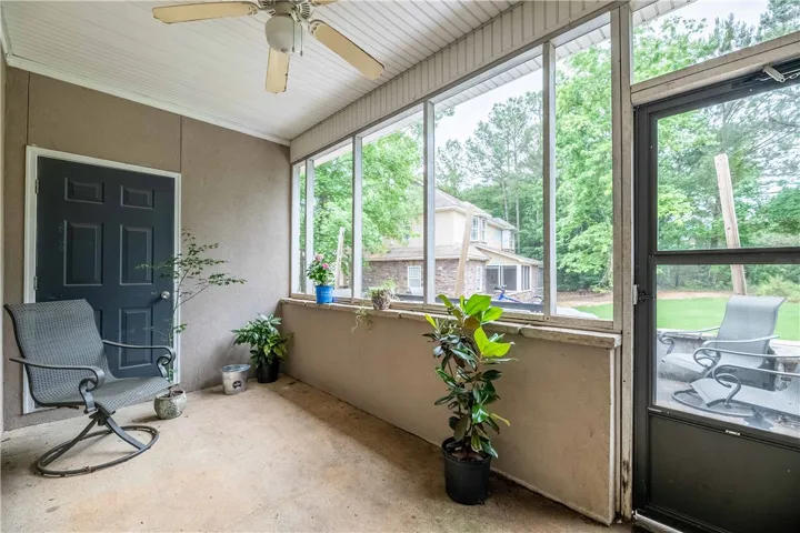 Enjoy outdoor living on this inviting screened porch, offering pleasant views of the natural surroundings.