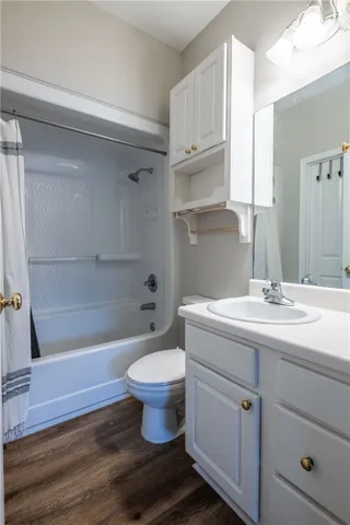 A well-lit bathroom features a functional vanity and a combined shower-tub unit, offering everyday comfort.