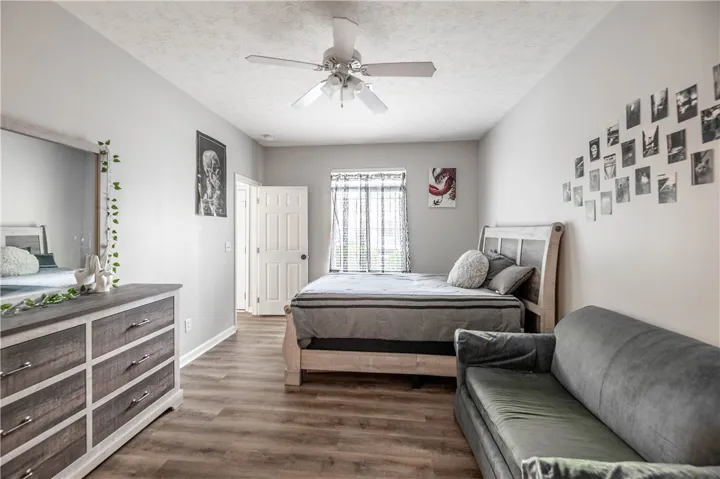 This restful bedroom offers durable flooring and a refreshing ceiling fan.