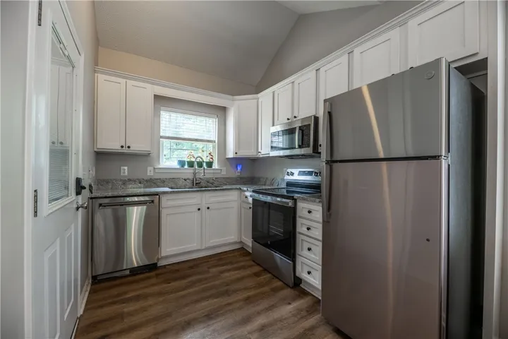Culinary delights await in this modern kitchen with granite counters and rich wood-look flooring.