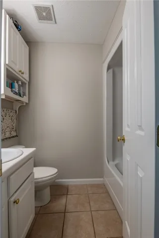Functional full bathroom offering practical design and ceramic tile flooring.