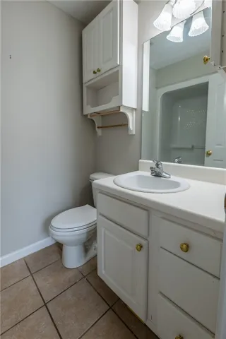 Functional bathroom featuring tile flooring, a convenient vanity, and integrated storage solutions.