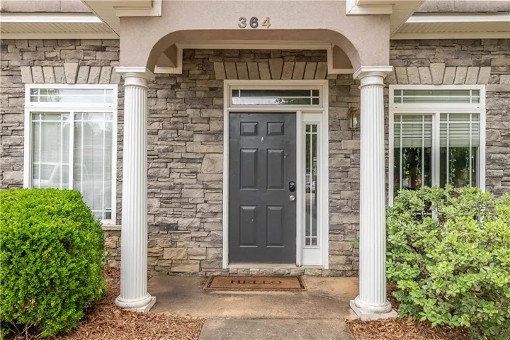 A welcoming front entrance, framed by columns, offers a glimpse of the home's meticulous stone facade.