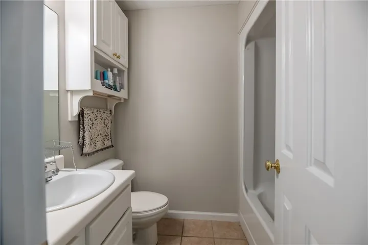 A compact and functional bathroom features a clean vanity, toilet, and a practical shower-tub combination.